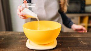 Female Hands Adds Sugar into a Bowl with Dough