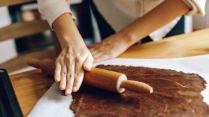Person Flattening a Dough With Rolling Pin