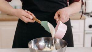 Woman in Black Apron Holding Pink Plastic Spoon