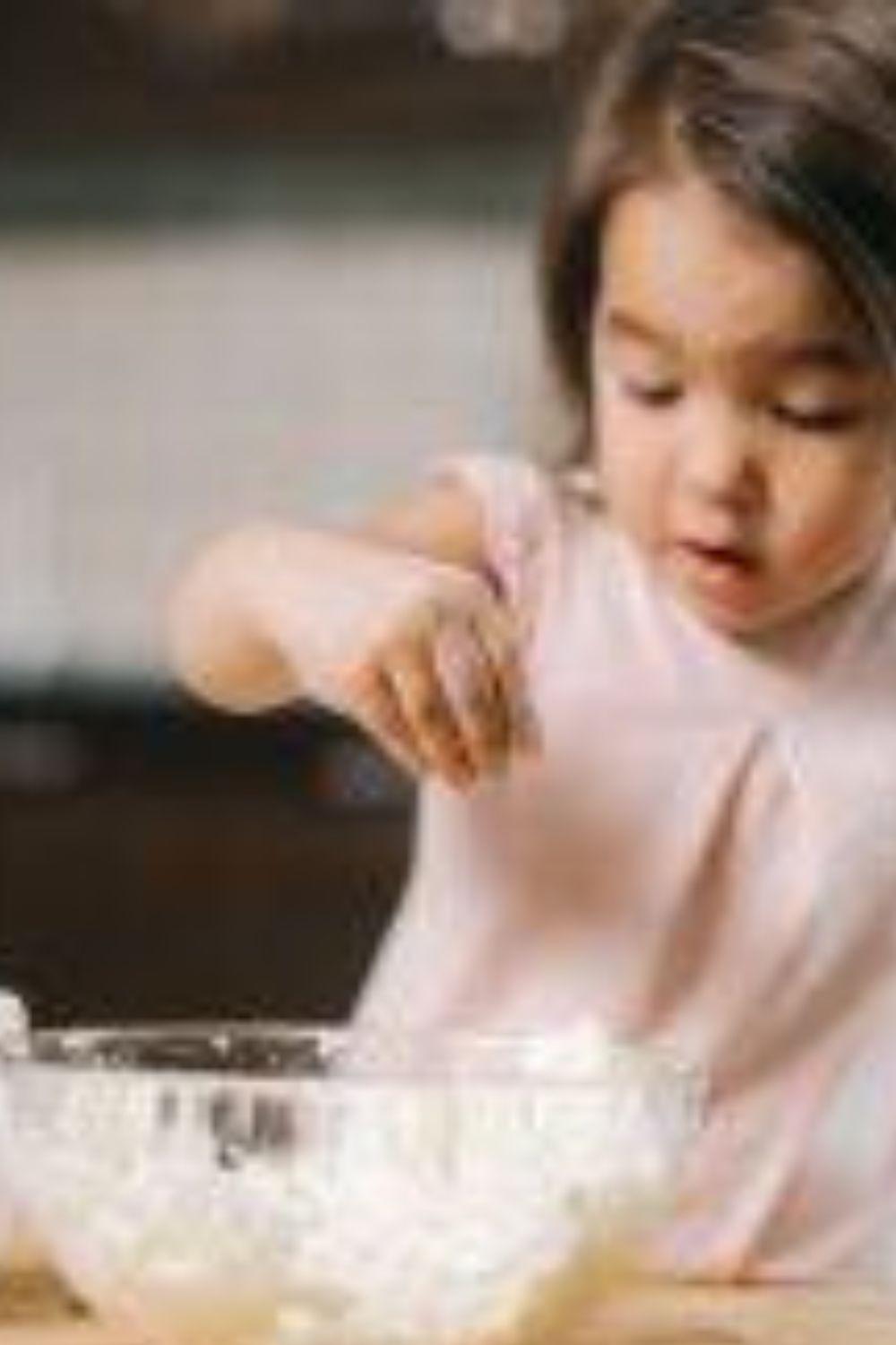 a baby girl mixing dough